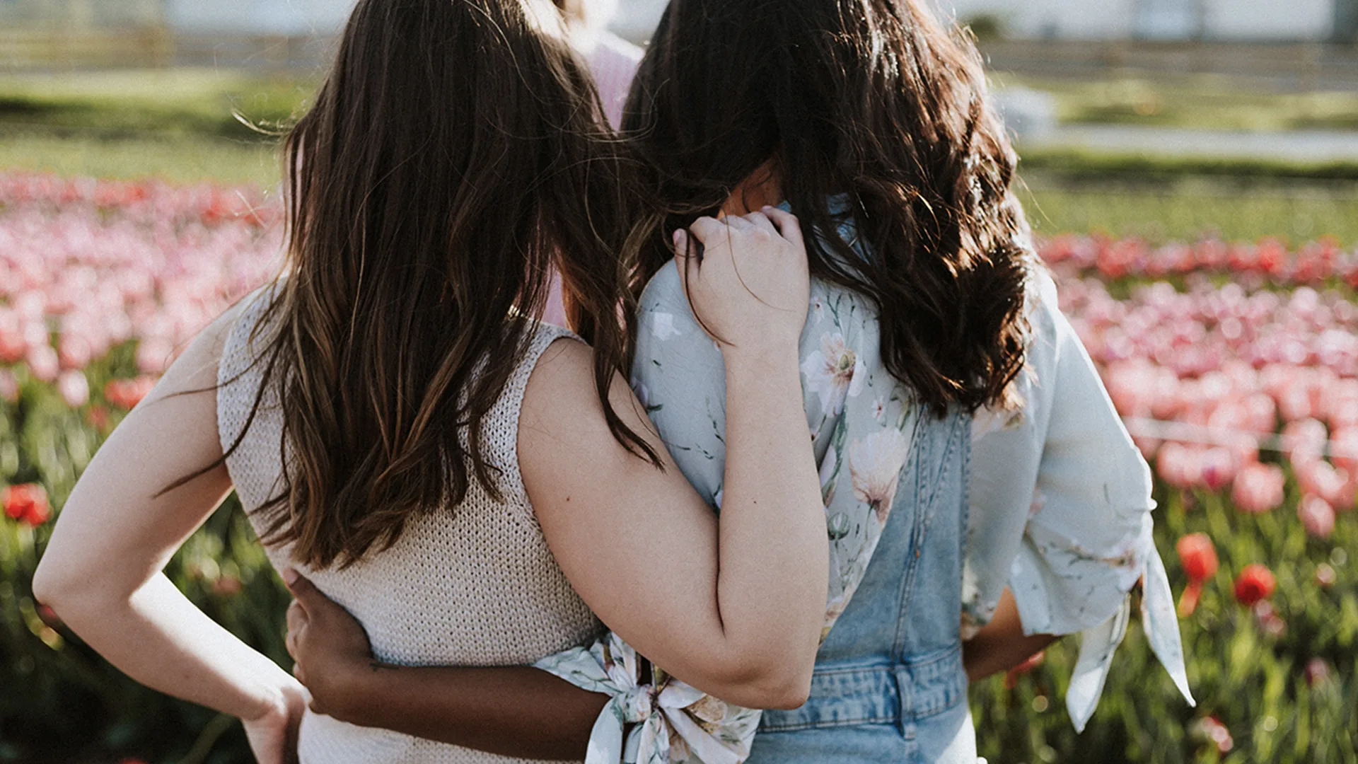 Two women with their arms resting on the others back