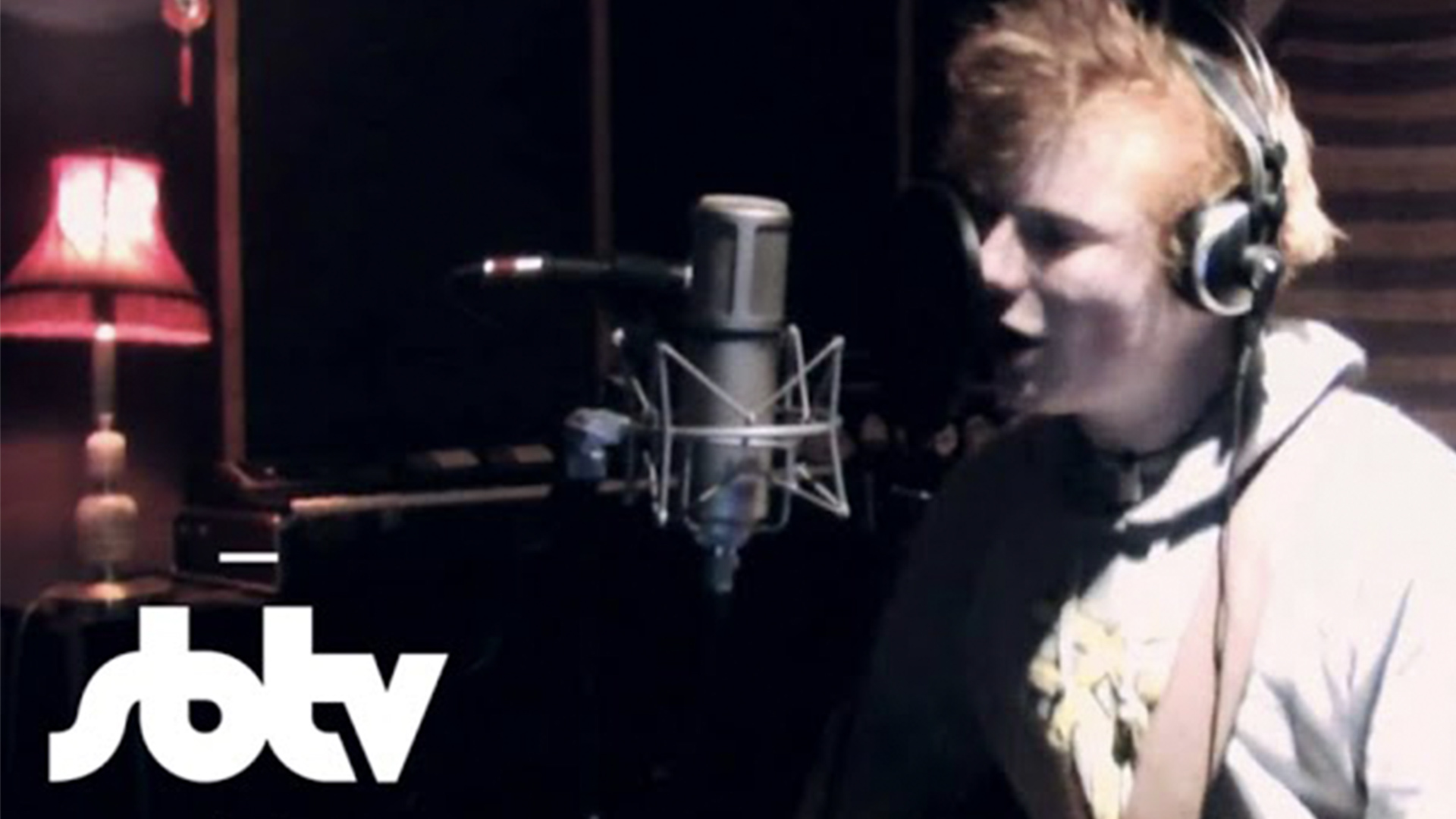 Ed Sheeran singing into a microphone