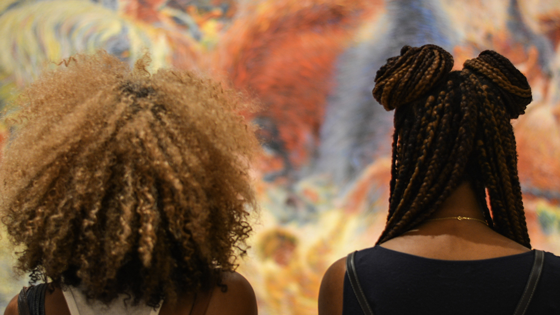 Two women with curly and braided hair