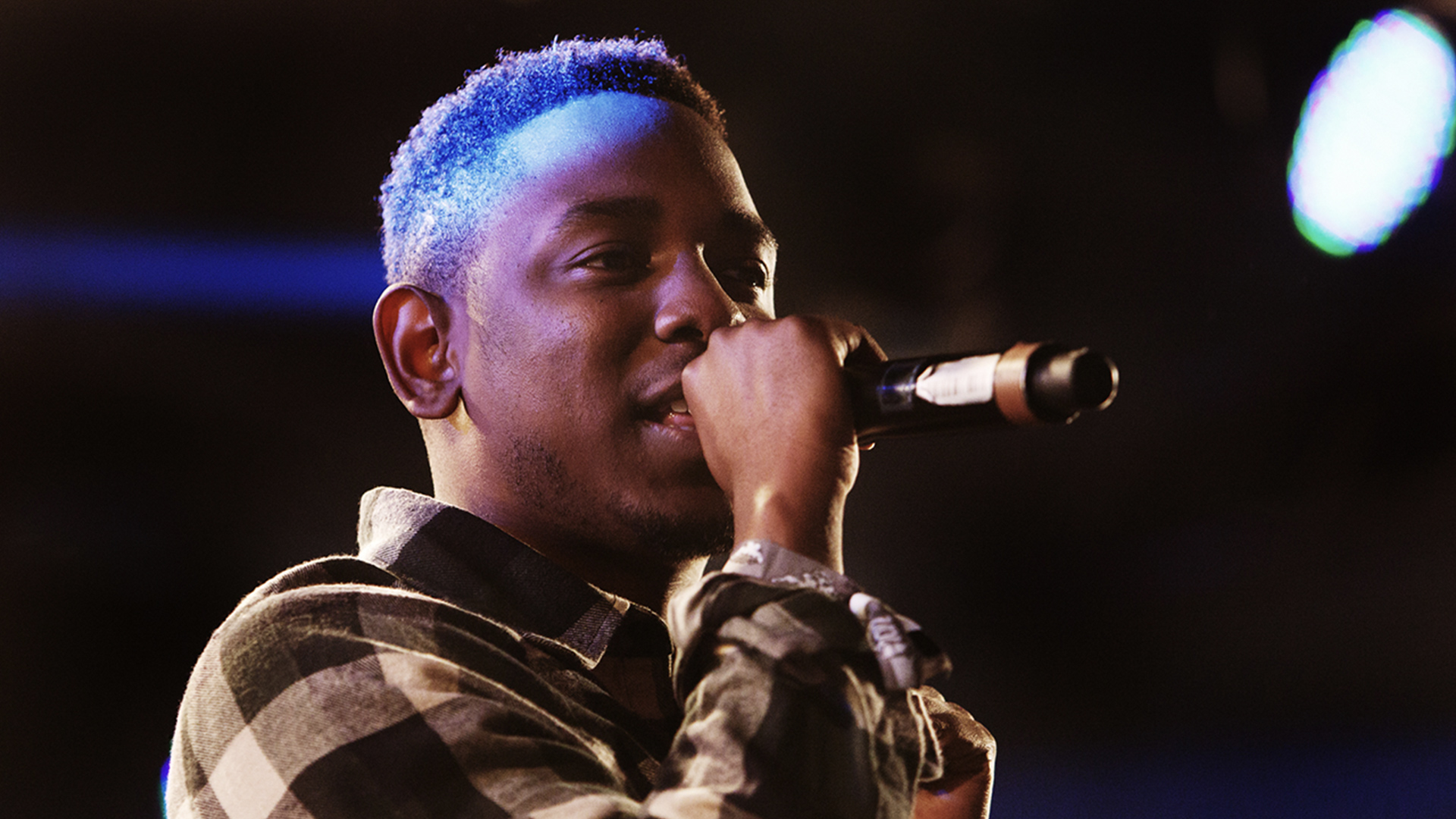 Young Kendrick Lamar rapping into a microphone