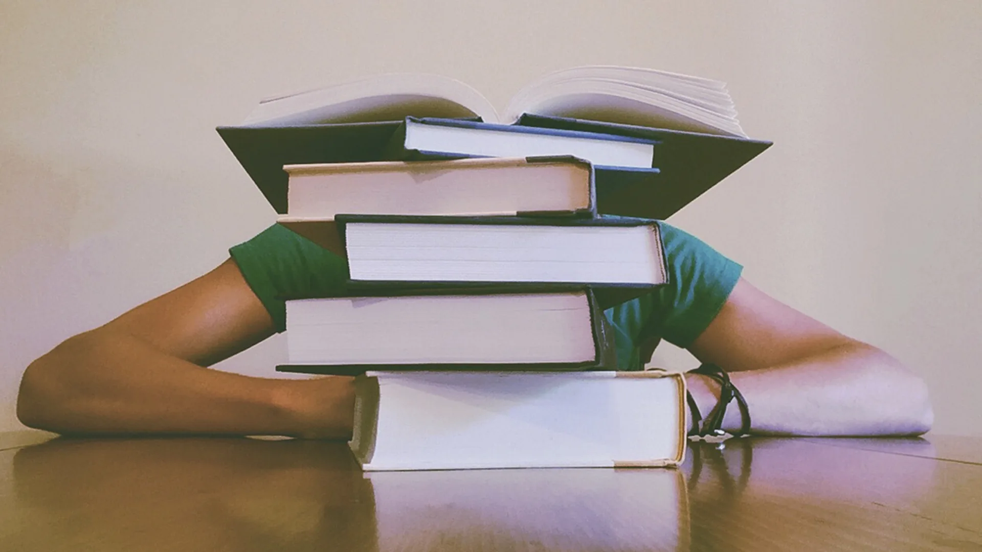 Person behind a stack of books