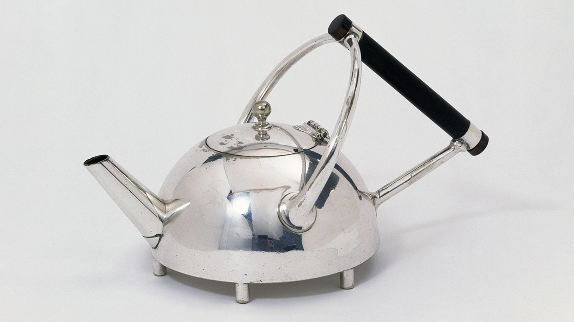 Silver teapot with three pronged handle