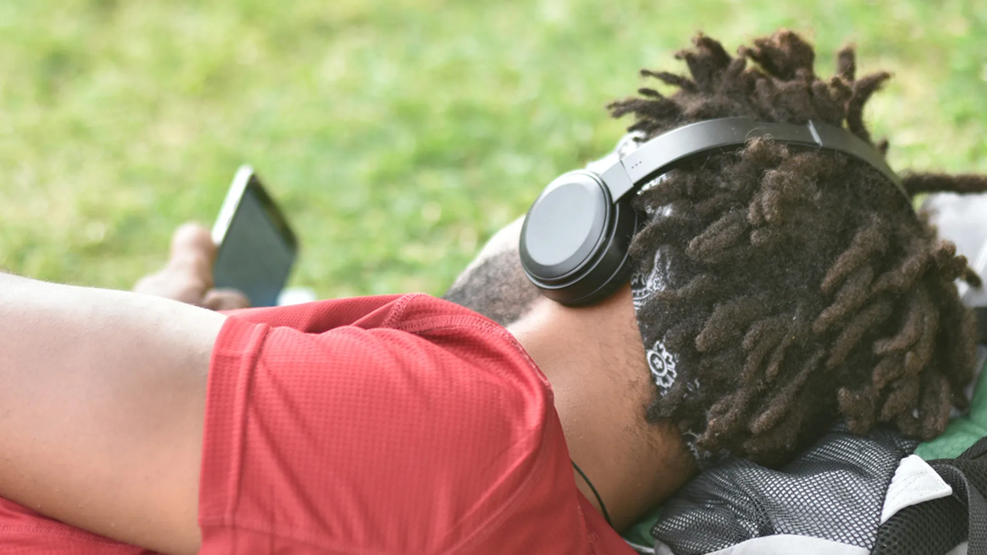 Man lying down in the park listening to music