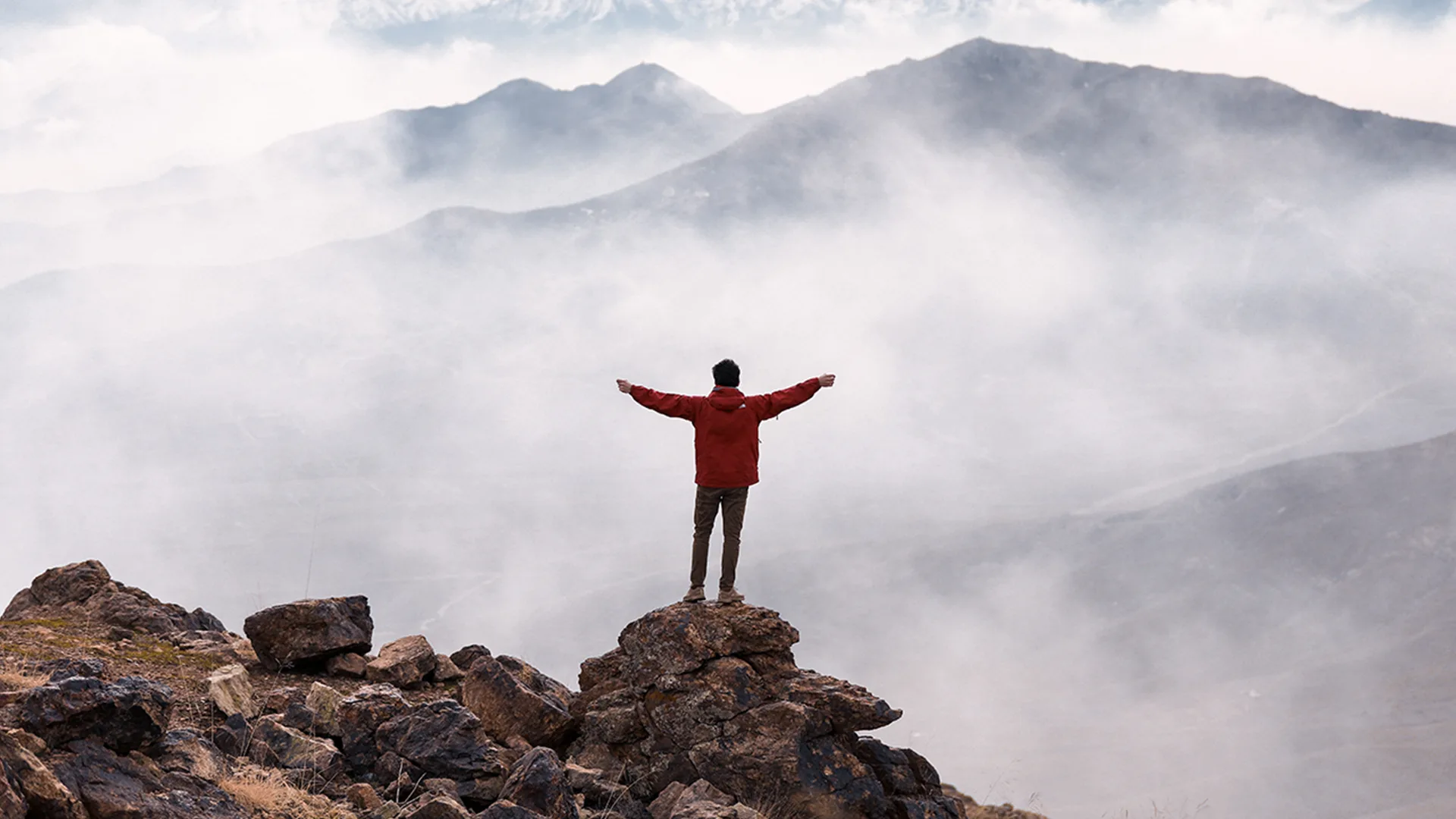 Person standing on the edge of a mountain