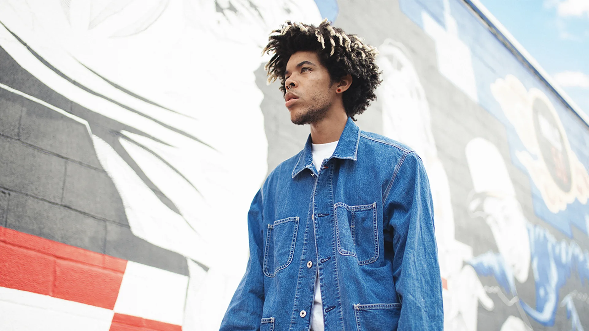 Man in denim jacket walking down the street