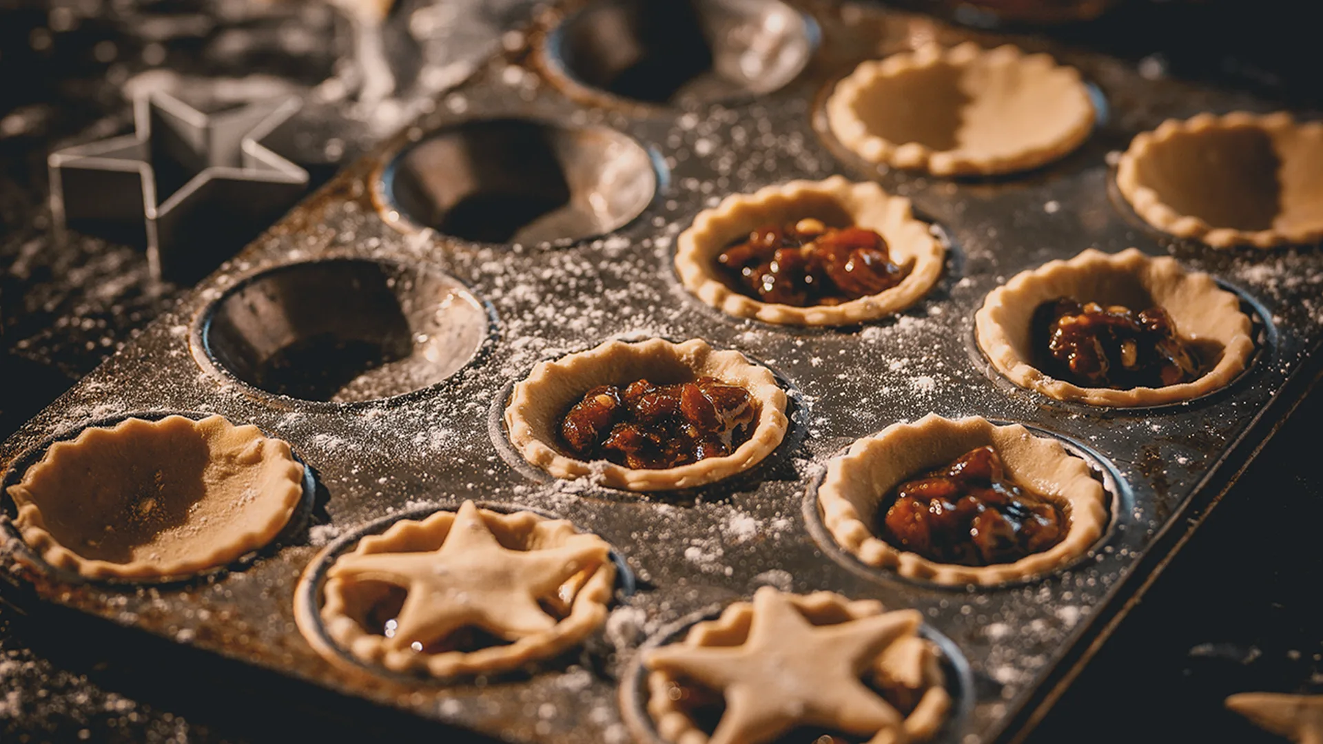 Mince pies in baking tray duste with icing sugar