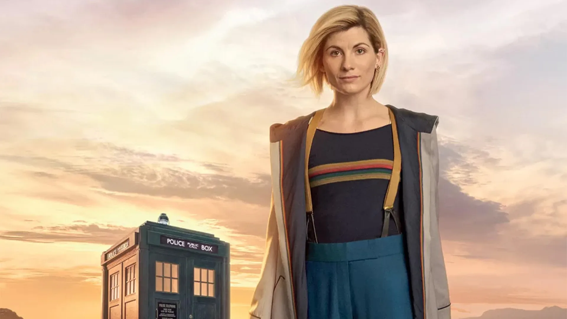 Actor Jodie Whittaker stood infront of tardis with countryside backdrop