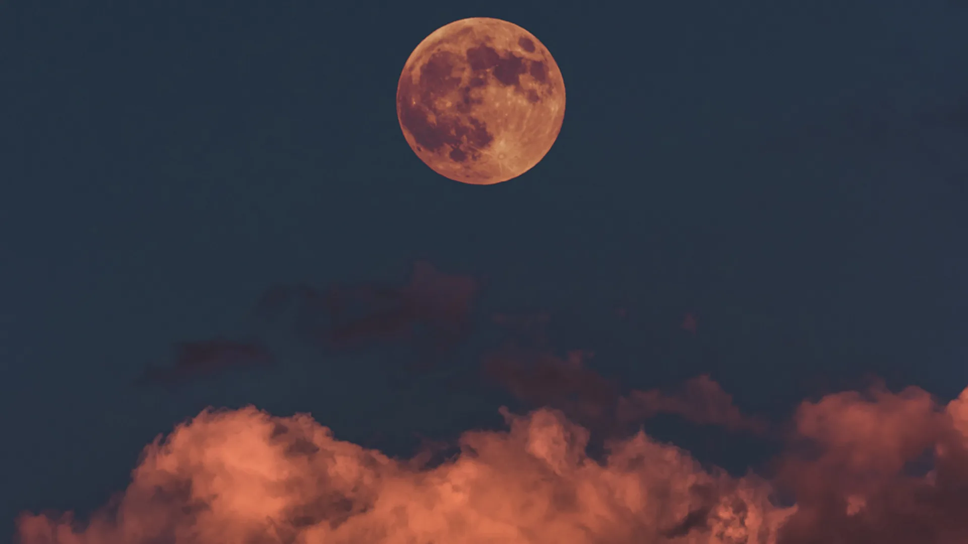 A red full moon in the night sky