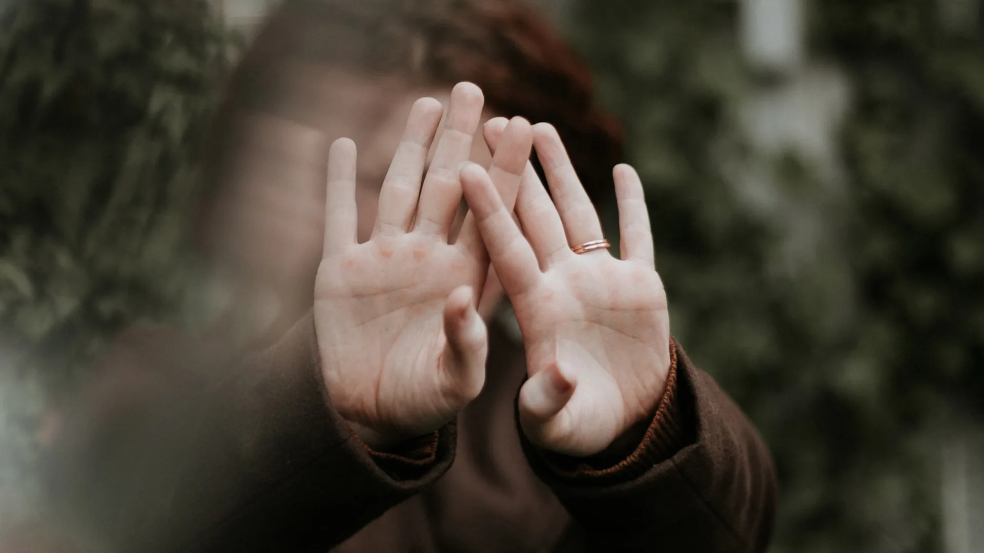 A person holding their hand in front of their face