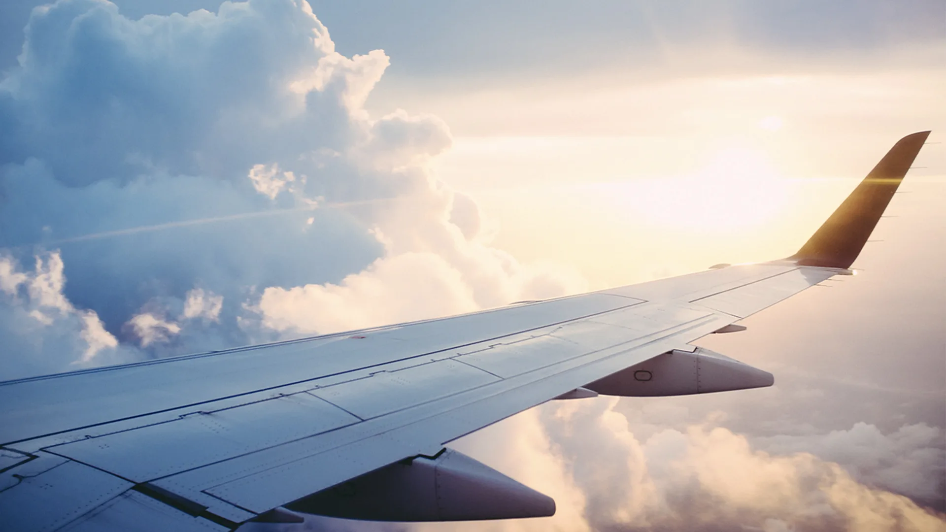 A plane mid flight with cloud in the background