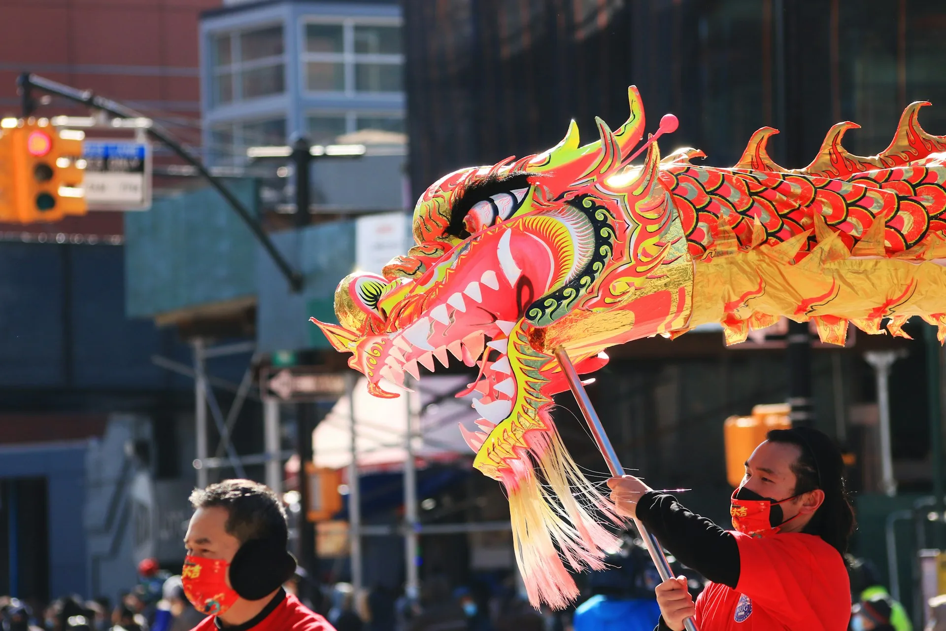person in red shirt holds dragon puppet