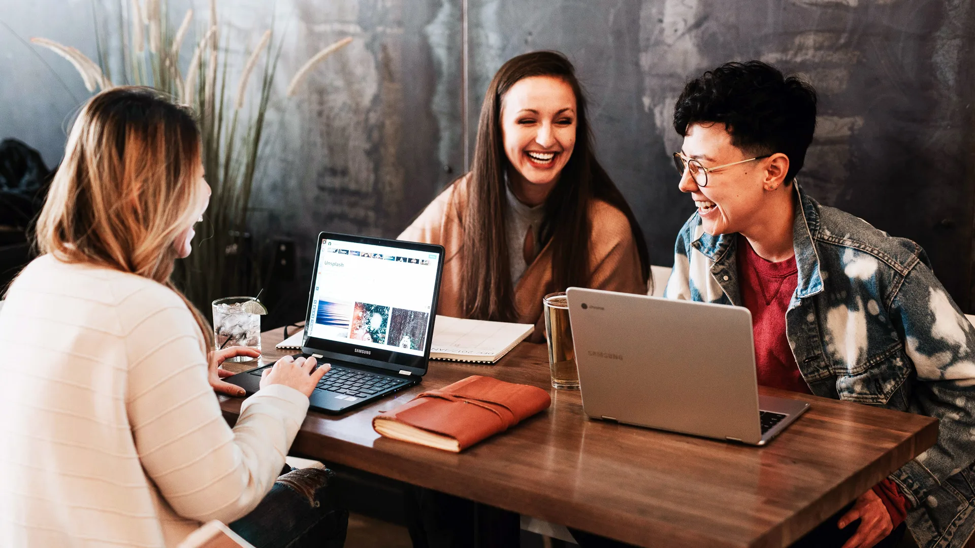 Group of people laughing at a table with computers