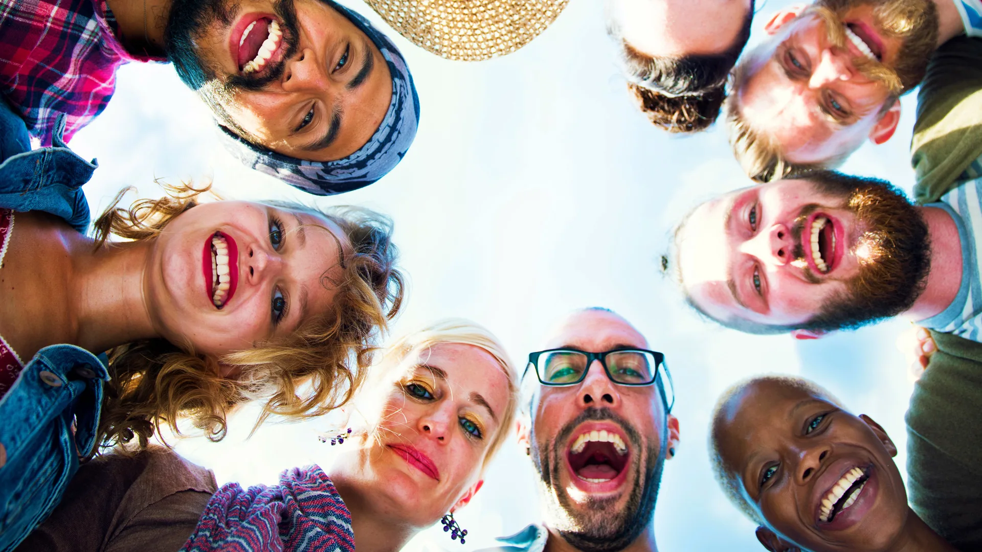 Group of people looking down towards the camera with the sky in the background 