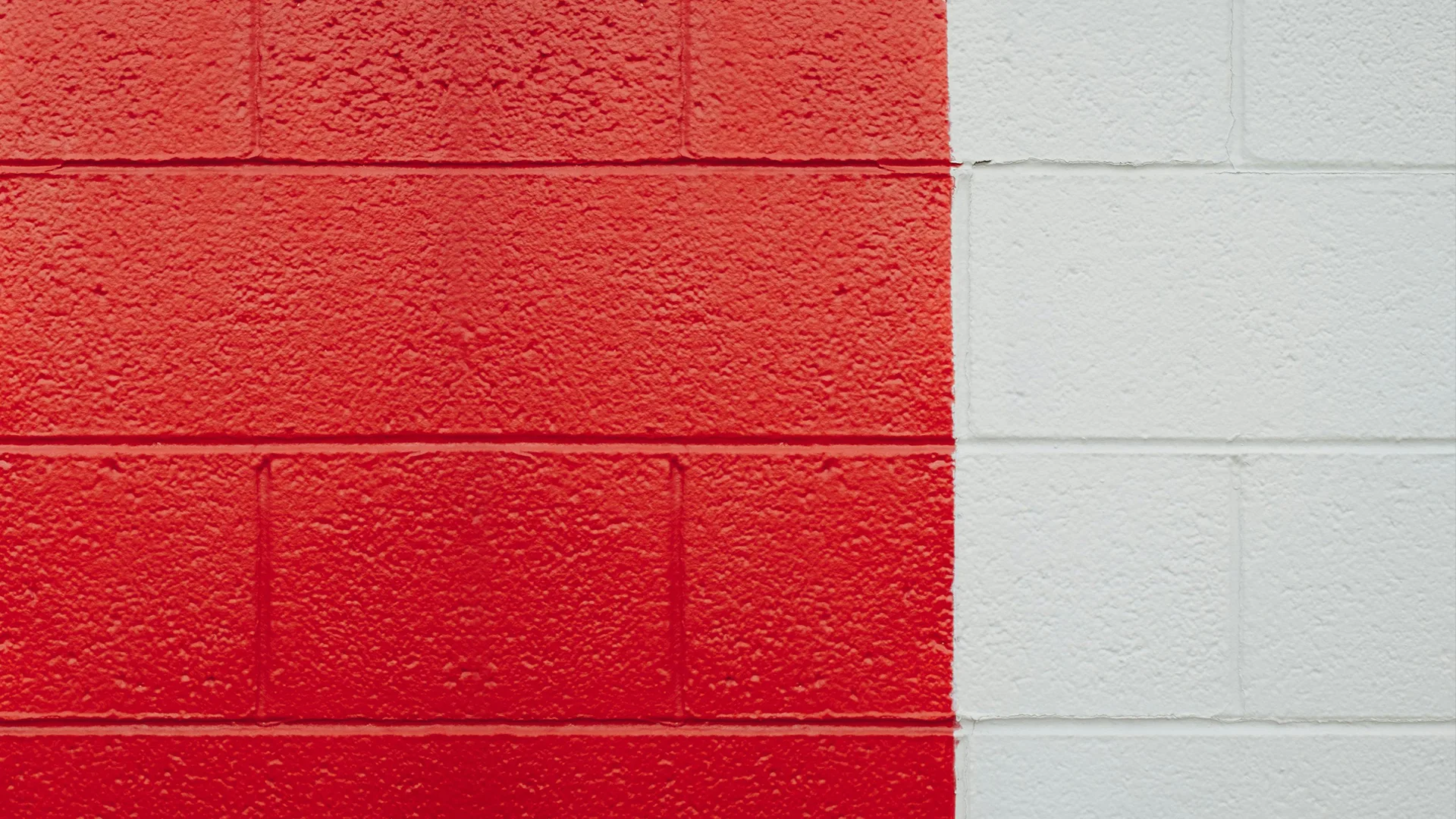 Brick wall painted half white and half red