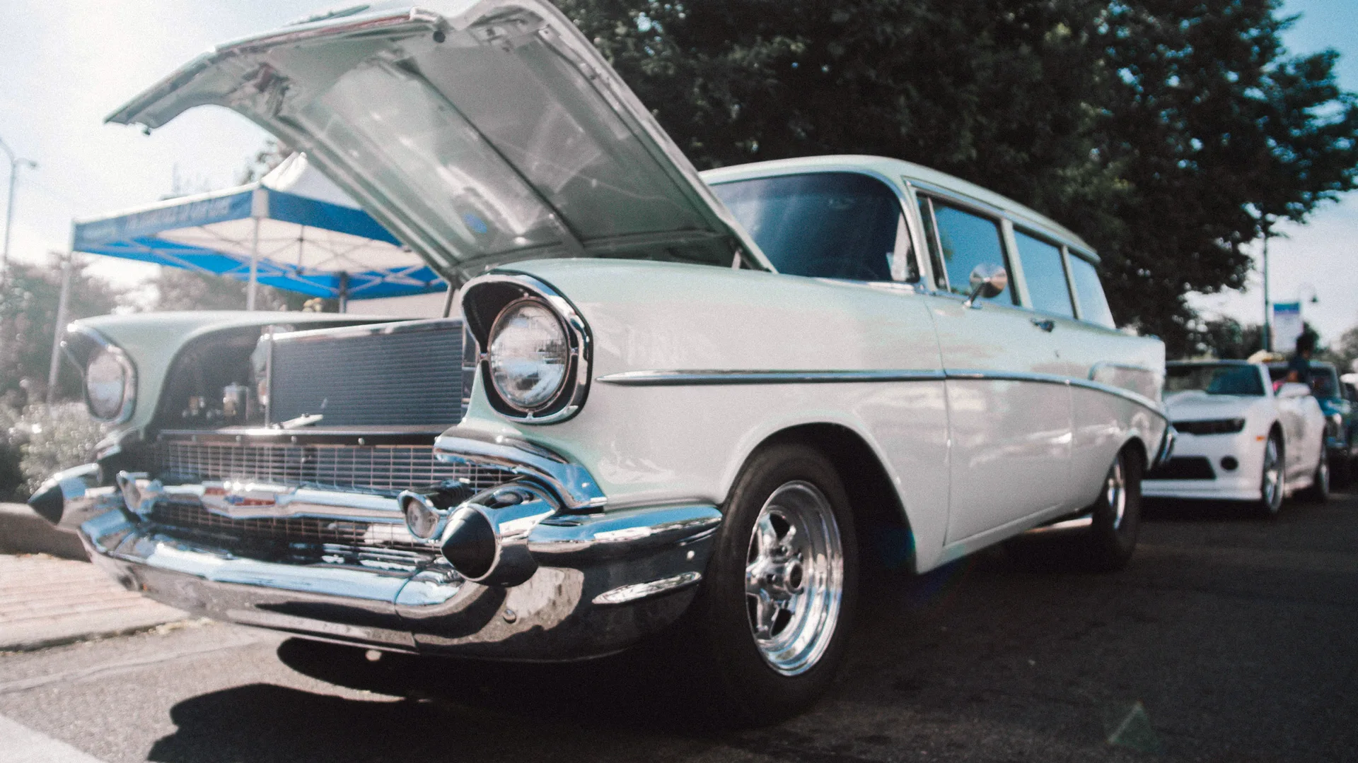 A photograph of a white car with the boot open