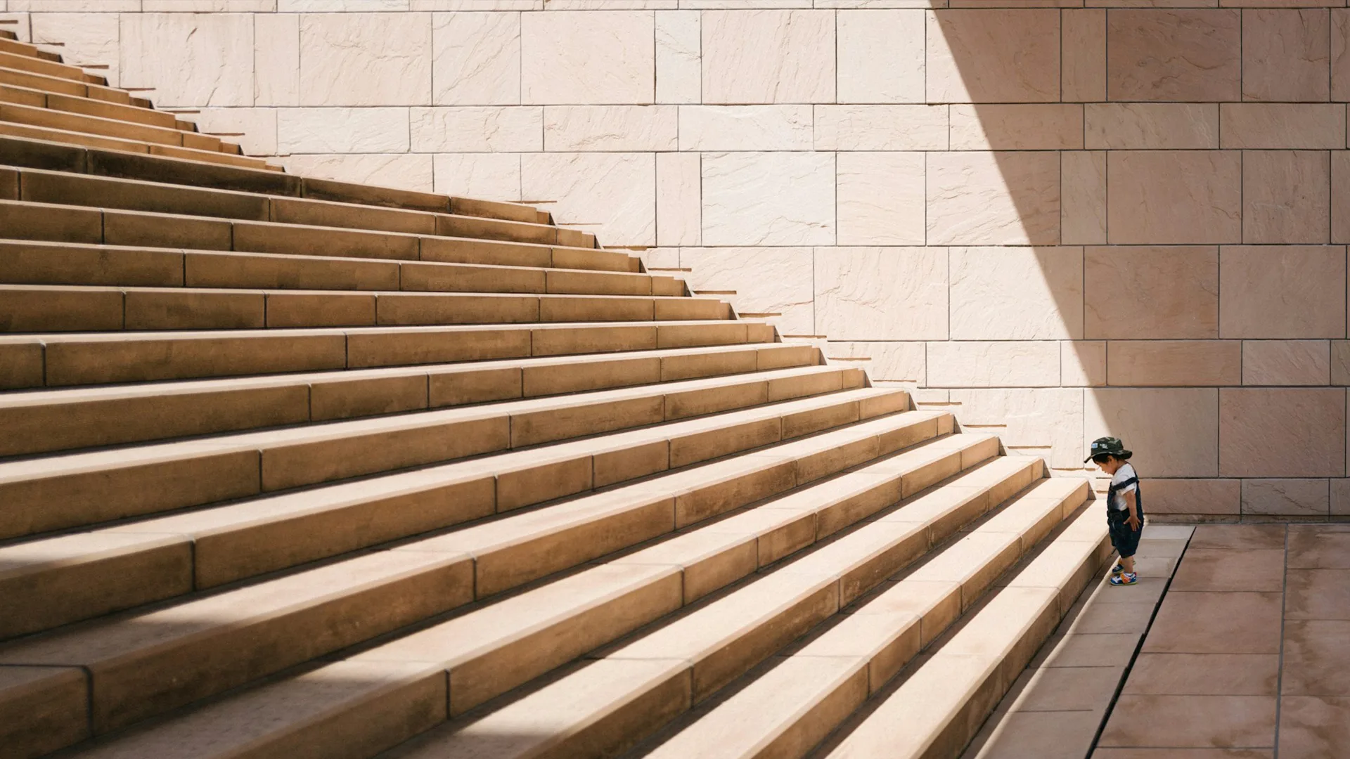 Toddler standing in front of beige concrete stairs